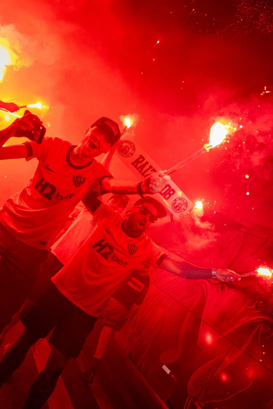 O uniforme é confeccionado predominantemente em tons laranja, reproduzindo o brilho e o impacto visual dos sinalizadores que transformam a noite de Belo Horizonte em um espetáculo de luz e fogo